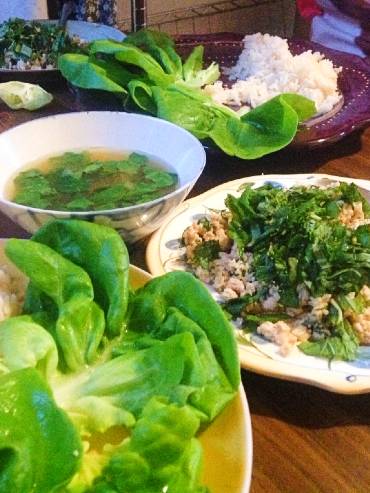 Chicken larb on lettuce leaves with rice and broth.