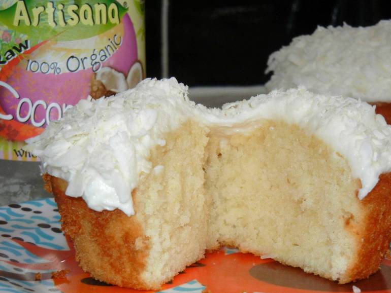 Money shot of coconut cupcake with inside exposed.